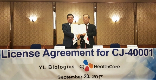 CJ헬스케어 강석희 대표(왼쪽)와 YL Biologics의 토시히코 히비노 대표(오른쪽)가 계약서를 들고 기념사진을 찍고 있다.