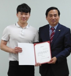 윤종일 회장(오른쪽)이 홍재준 학생에게 장학증서를 전달하고 있다.