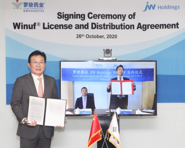 JW홀딩스 한성권 대표(왼쪽)와 산둥뤄신제약그룹 라이언 리우(Ryan Liu) 대표(오른쪽)가 3체임버 종합영양수액제 위너프에 대한 '기술수출 및 공급 계약'을 체결하고 기념촬영을 하고 있다. (사진제공=JW홀딩스)