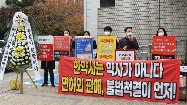 약사 직능에 애도를 표하는 근조화한 조형물과 한약사 불법판매 척결을 촉구하는 플레카드