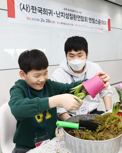 한국다케다제약 자원봉사자가 한 환우와 원예활동을 하고 있다.