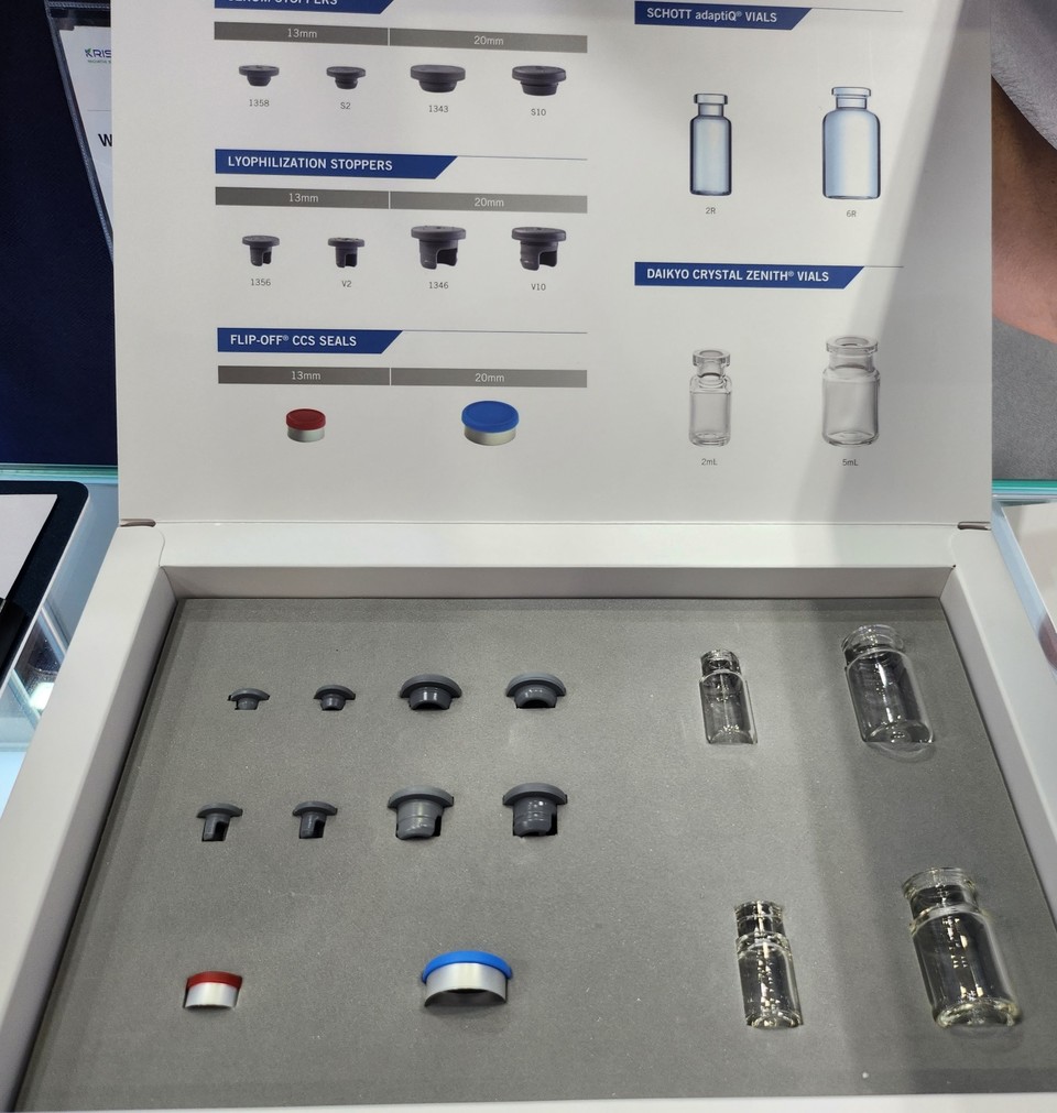 웨스트파마슈티컬의 제품 카탈로그. 회색의 고무마개, 빨간색과 파란색의 캡, 그리고 투명한 바이알이 진열돼 있다. / 사진=박성수 기자