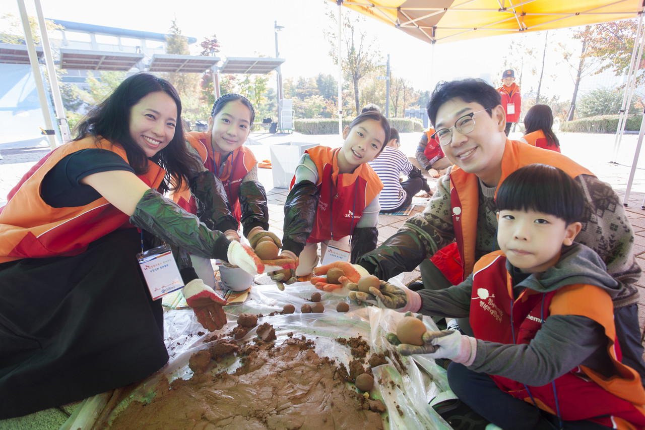 SK케미칼이 지난 28일 파주 운정호수공원 일대에서 하천 정화 가족 봉사활동을 진행했다.  SK구성원과 가족이 황토성분의 EM을 만들고 있는 모습 / 사진=SK케미칼
