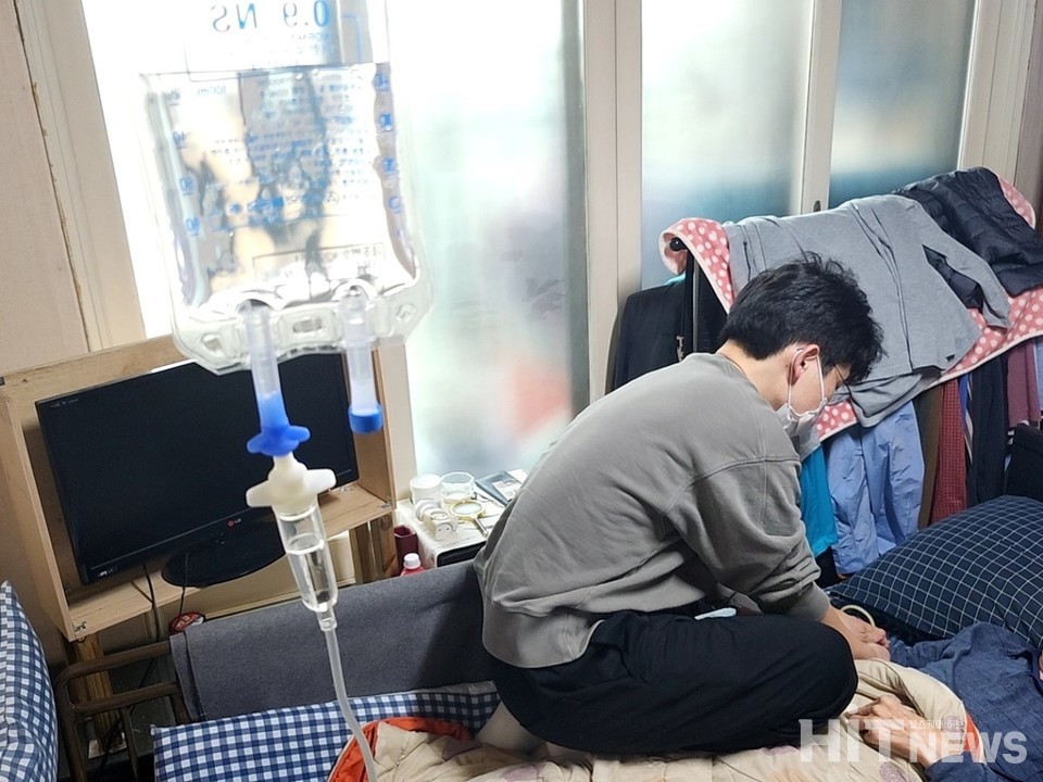 집으로의원 간호사가 침대 위로 올라가 링거액 주사를 놓고 있다. / 사진=박성수 기자