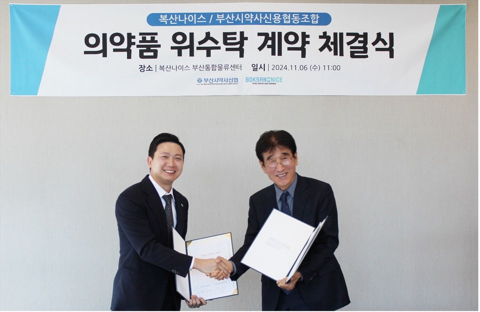(사진 왼쪽부터) 엄승욱 복산나이스 대표와 박성수 부산시약사신협 이사장이 계약서를 체결한 뒤 기념촬영을 하고 있다.