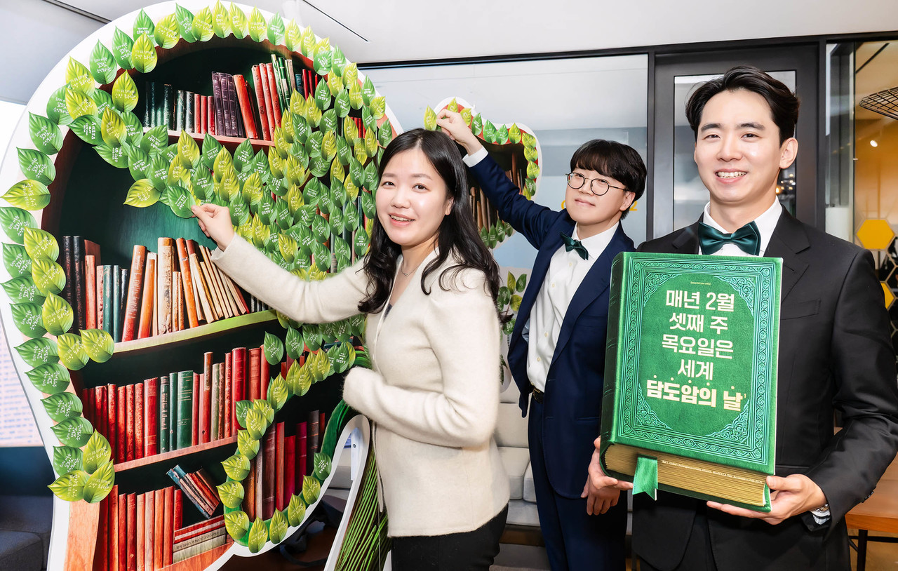 한국아스트라제네카 임직원들이 '소망 담도 나무'에 응원의 메시지를 부착하고 있다. 