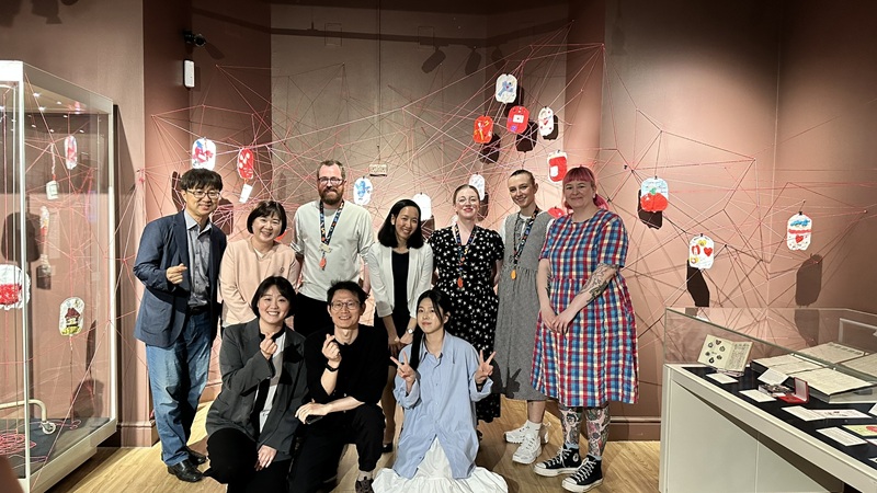 환우회와 리즈 새커레이 의학박물관, 리 바우저 작가팀의 전시 협업을 기념하며 단체사진. 전시 벽면에는 한국과 영국에서 제작된 로투스 바카라백 작품이 함께 전시됐다.