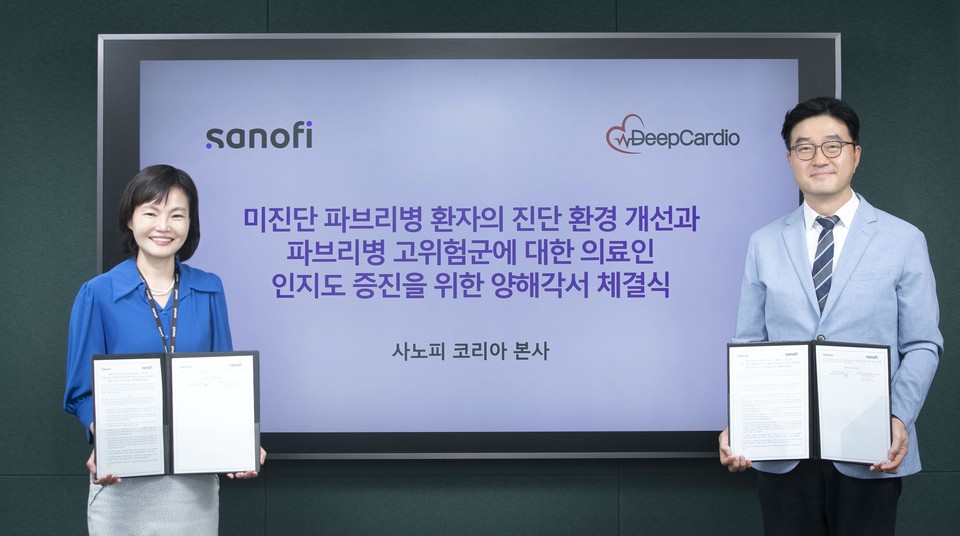 배경은 사노피 코리아 대표(왼쪽)와 최원익 딥카디오 대표이사가 '파브리병 진단 환경 개선'을 위한 MOU 체결을 마치고 기념촬영을 하고 있다. / 사진=사노피 코리아