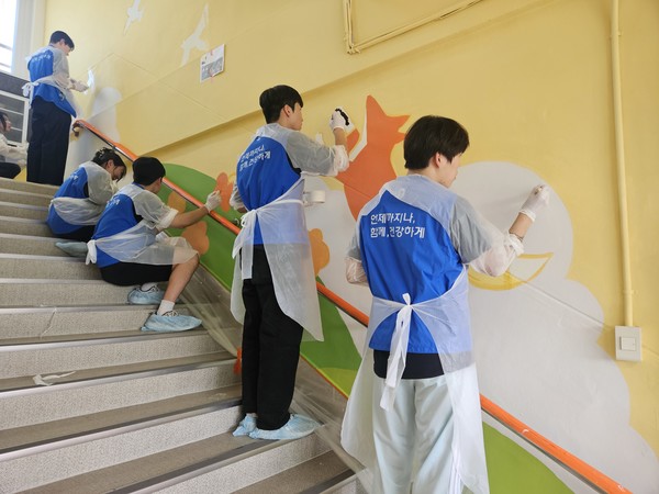 동아쏘시오그룹 신입사원들이 벽화를 채색하고 있다.
