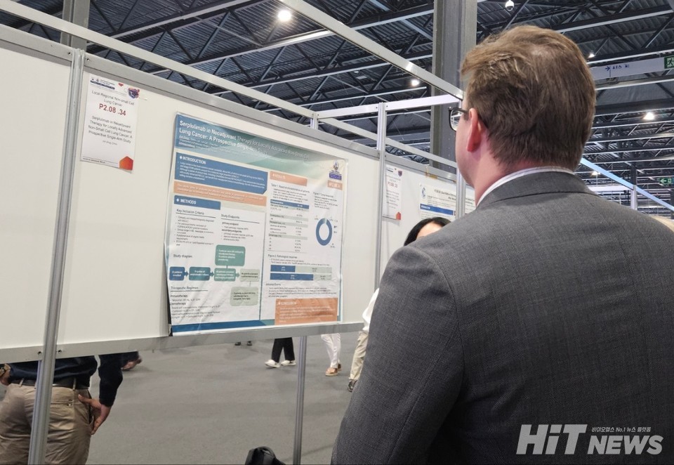 WCLC 참가자가 헤트론플라이 포스터를 보고 있다.